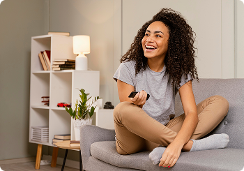 Mulher feliz sentada no sofá de casa