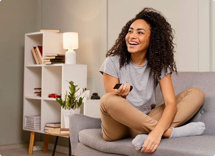 Mulher feliz sentada no sofá de casa